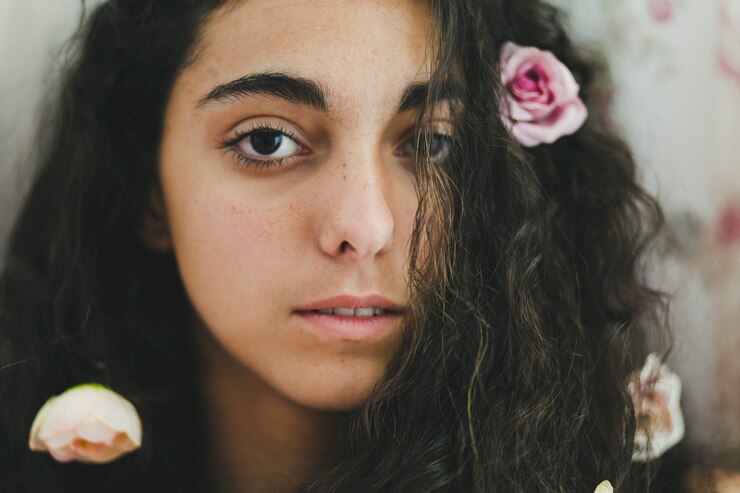 young woman with flowers hair looking camera